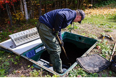 Técnico del servicio local de Premier Tech rastrillando el medio filtrante en el interior de un biofiltro Ecoflo.