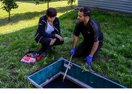 Premier Tech’s local service technician explaining the Ecoflo biofilter septic system maintenance to a customer.