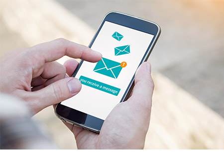 Man holding a mobile phone that displays an email notification.