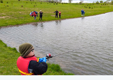 Des enfants pêchant dans la rivière Maquoketa au Camp Courageous en Iowa.