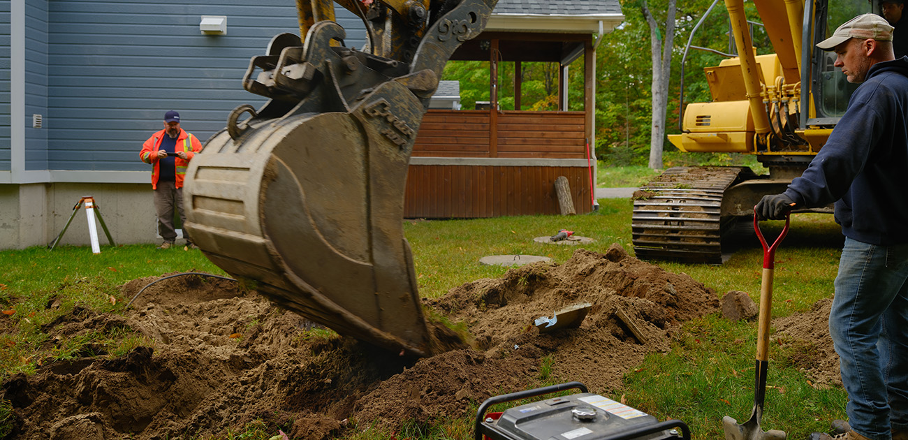 Excavateur installant un système septique de type Bionest sur une propriété rurale au Québec, Canada.