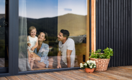 Famille souriante qui regarde par la fenêtre