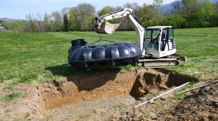 Pelle mécanique hydraulique installe un récupérateur d'eau de pluie Rewatec