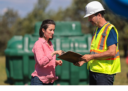 Propriétaire et installateur septique s’entretenant avant l’ouverture du chantier.