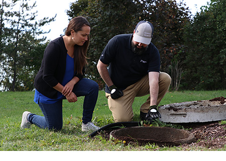 Premier Tech Water and Environment technician inspecting a homeowner's septic system in Québec, Canada.