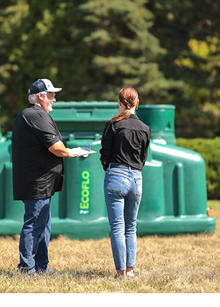 Customer talking to a Premier Tech Water and Environment specialist in front of an Ecoflo biofilter.