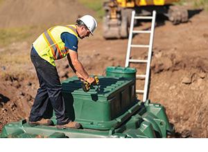 Installateur septique au Québec fermant l'accès principal d'un biofiltre compact Ecoflo en polyéthylène.