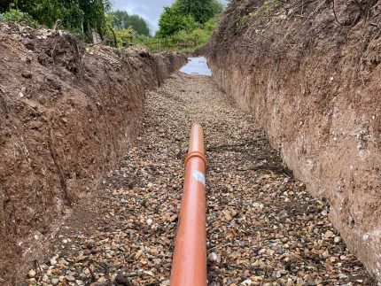 Trenching for wastewater discharge to a drainage field.