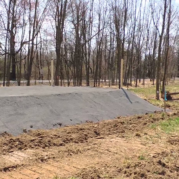 Large sand filter septic system being installed at the site of a new home construction.