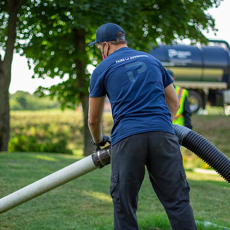 Technician performing the sludge removal a septic system.