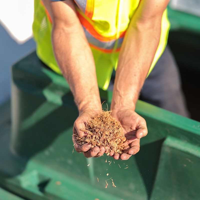 Premier Tech Water and Environment installer holding the Ecoflo septic system's coconut husk fragment filtering medium.