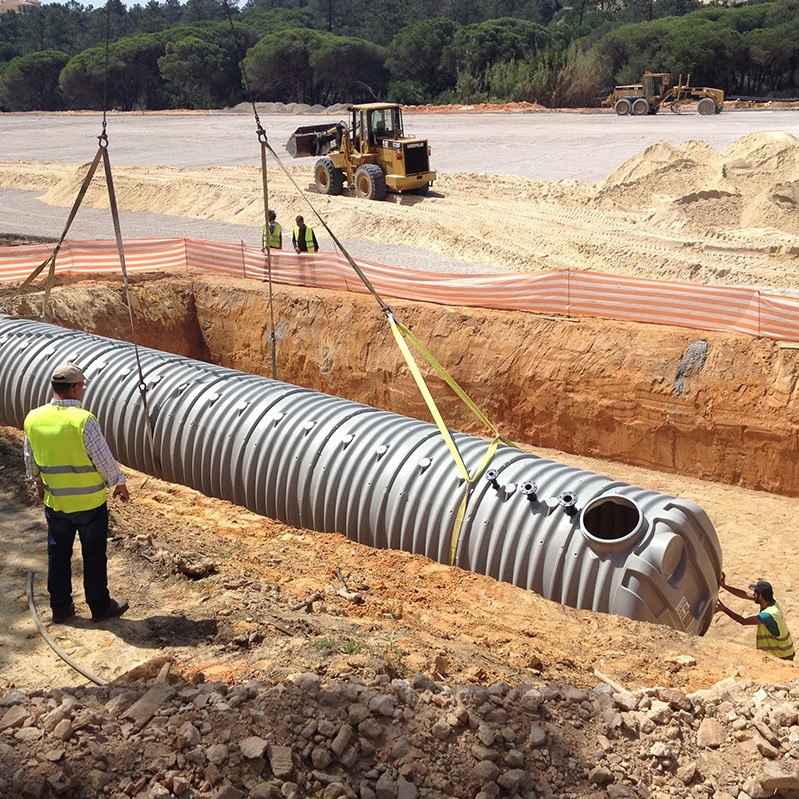 Premier Tech Water and Environment installers lowering the Rewatec underground water storage tank into an excavation in Portugal.
