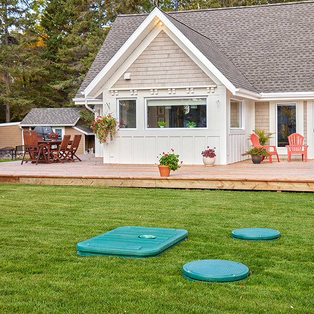 Ecoflo septic system lids installed on a rural property versus public sewer manhole lids installed on a city street.