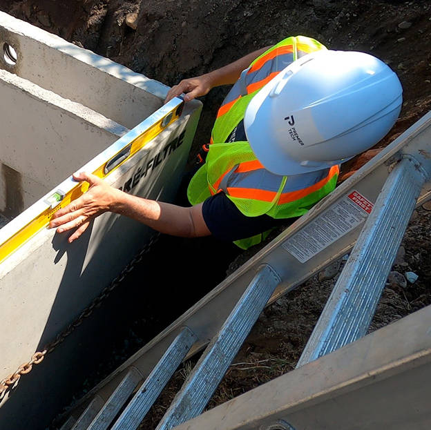 Premier Tech Water and Environment installer making sure that a septic tank is level before backfilling.