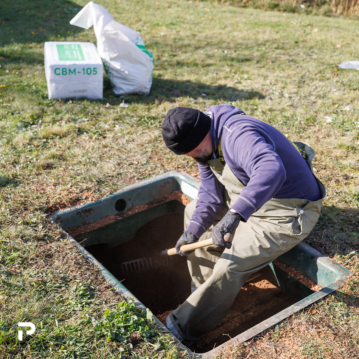 Technicien Premier Tech Eau et Environnement faisant l'entretien d'un biofiltre Ecoflo.