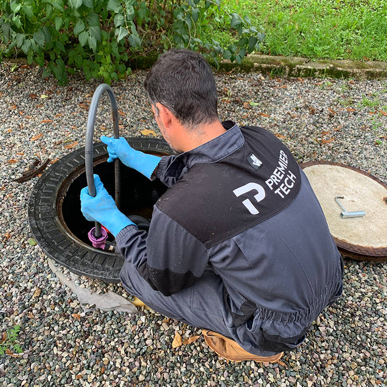 Premier Tech Water and Environment technician inspecting and wiring a wastewater treatment system in the UK.