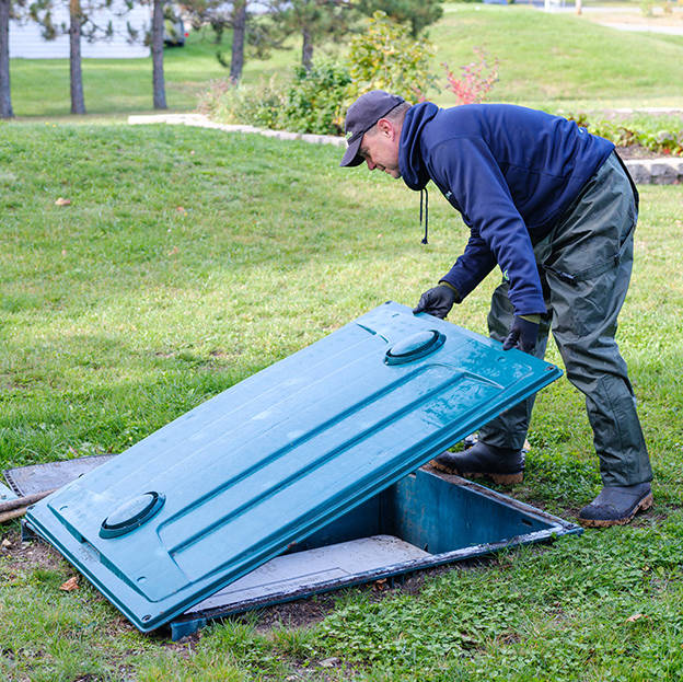 Technicien Premier Tech Eau et Environnement vérifiant le bon fonctionnement du biofiltre compact Ecoflo.