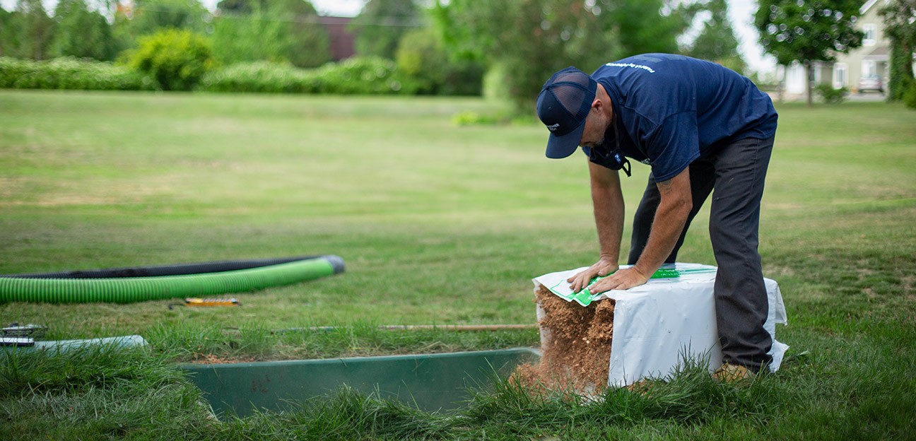 Man installing a coconut husk fragment filter in an Ecoflo biofilter septic system.