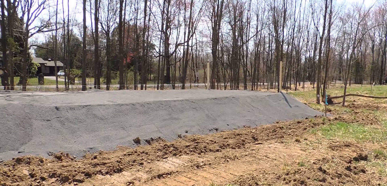 Large sand filter septic system being installed at the site of a new home construction.