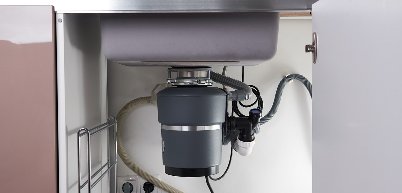 Garbage disposal system installed under a kitchen sink in a residential property.