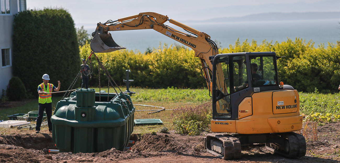 Excavator and septic installers lowering the Ecoflo biofilter septic system into a residential property.