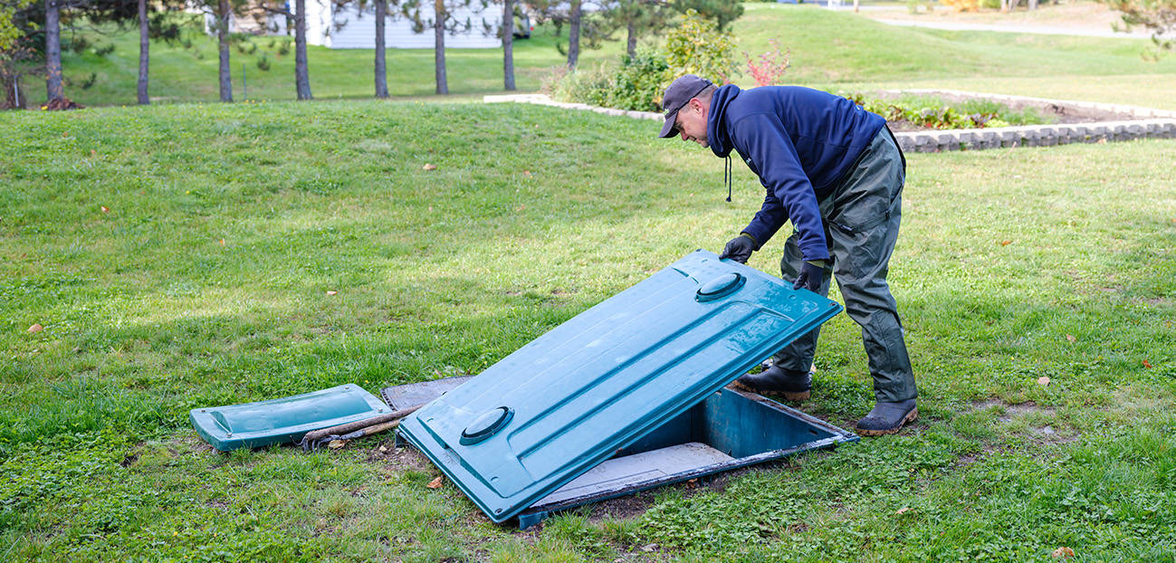 Technicien Premier Tech Eau et Environnement vérifiant le bon fonctionnement du biofiltre compact Ecoflo.