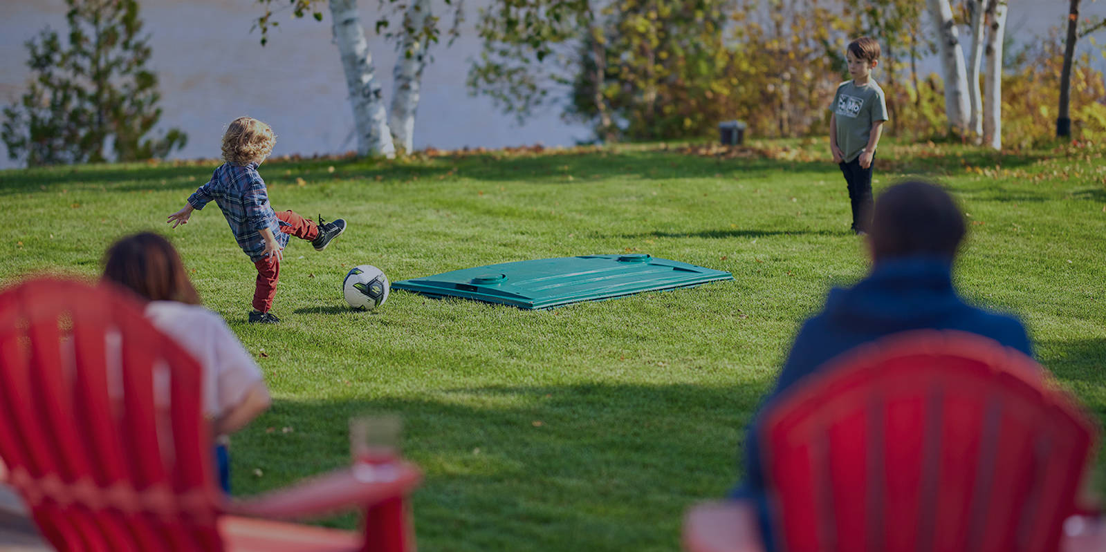 Children playing near the Ecoflo biofilter septic system installed on a cottage property near a lake in Québec, Canada.