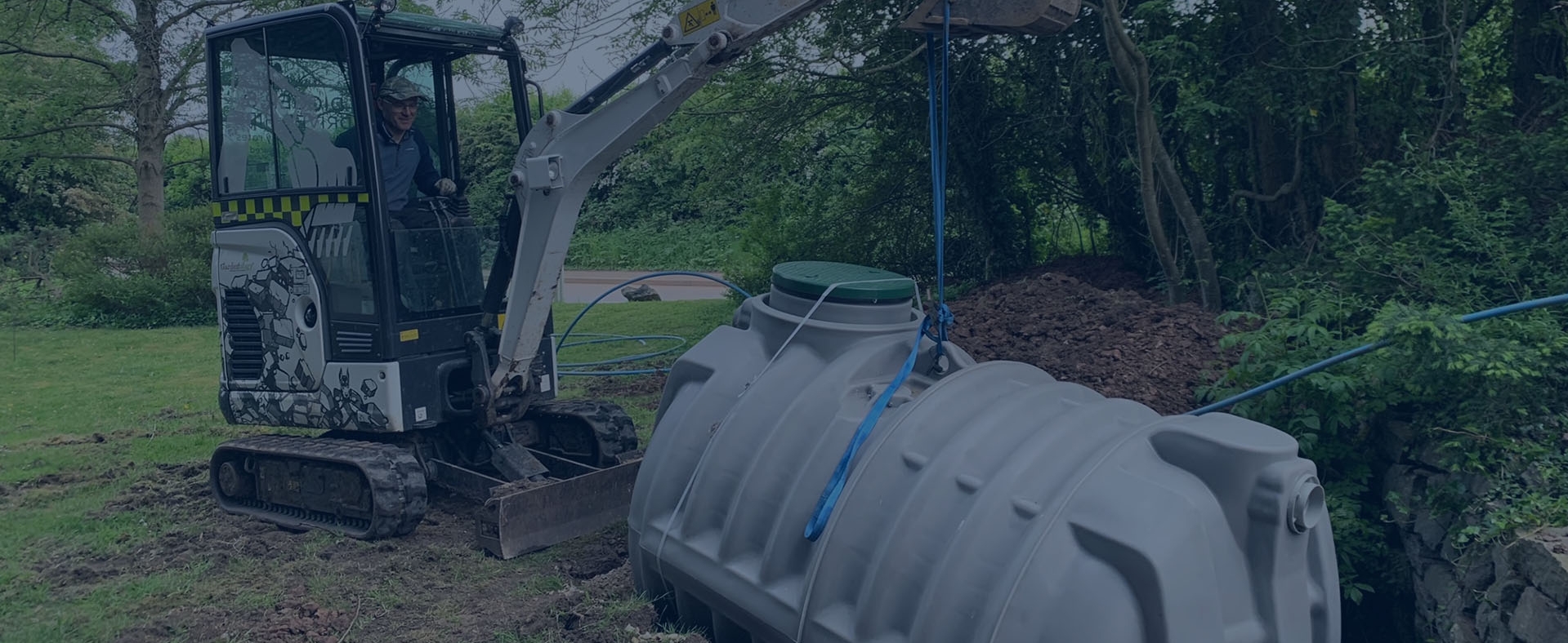 Excavator installing the Rewatec septic tank on a forested property in the United Kingdom.