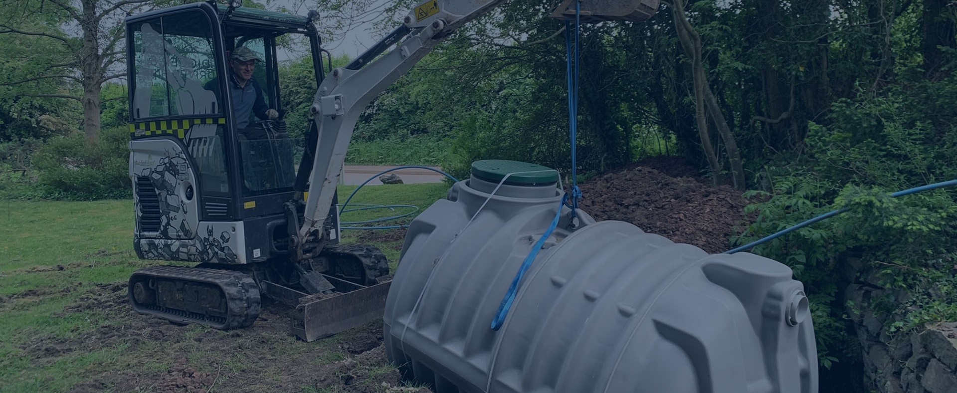 Excavator installing the Rewatec septic tank on a forested property in the United Kingdom.