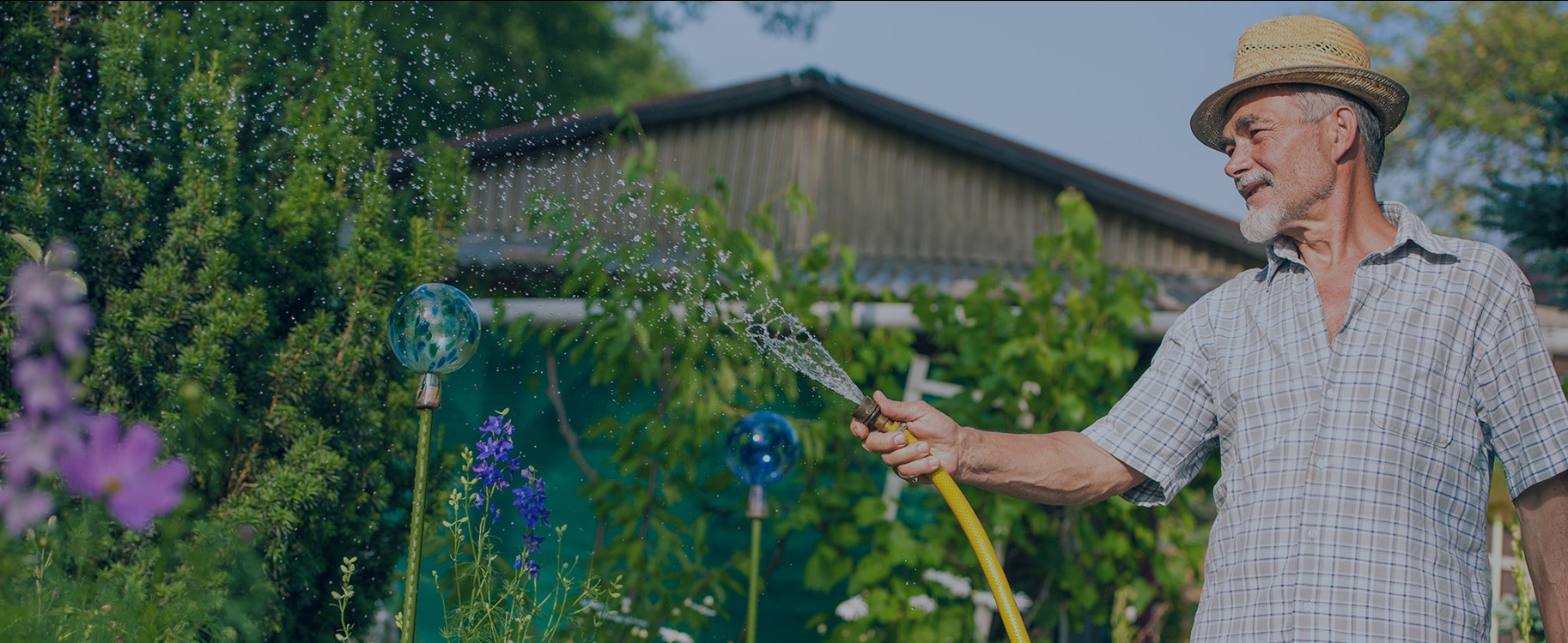 Man watering his garden with water collected from the Rewatec rainwater harvesting system.