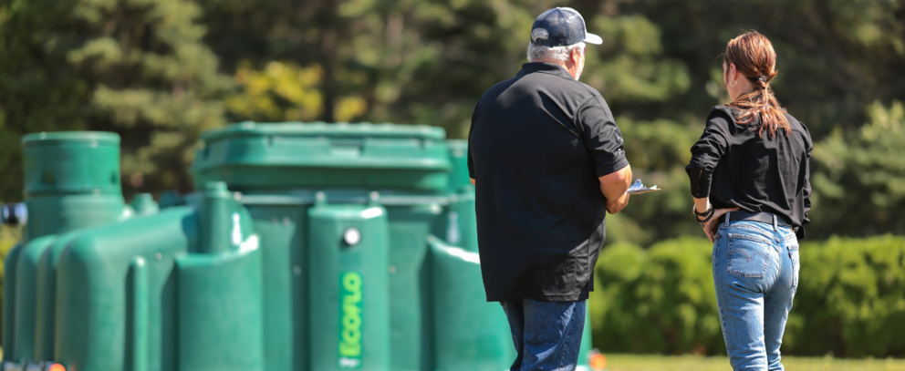Client discutant avec un expert Premier Tech devant une biofiltre Ecoflo.