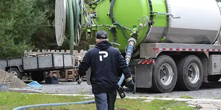 Premier Tech technician going to the vacuum truck for sludge removal.