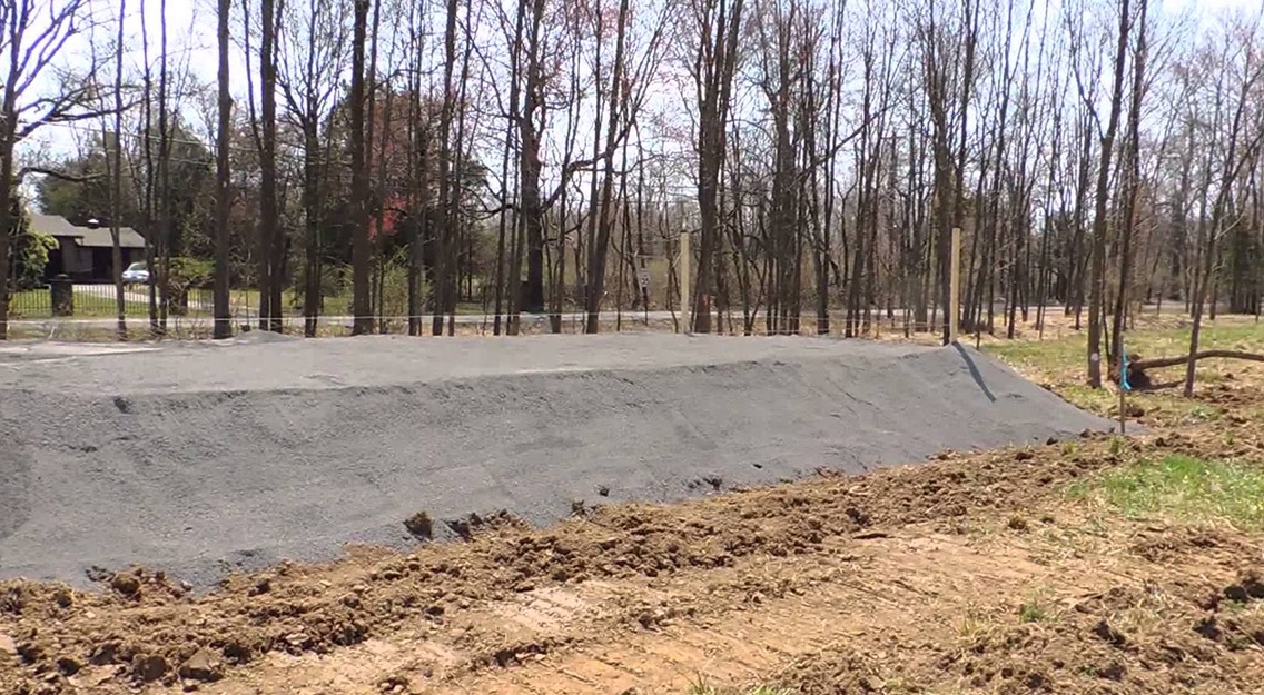 Large sand filter septic system being installed at the site of a new home construction.