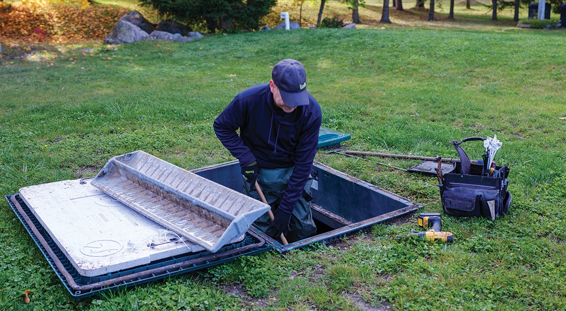 Technicien de service de Premier Tech qui entretient un système septique Ecoflo.