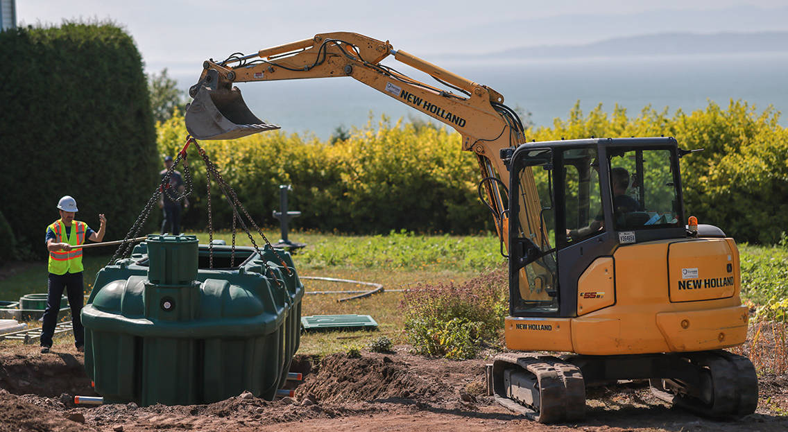 Excavator and septic installers lowering the Ecoflo biofilter septic system into a residential property.