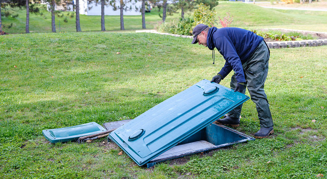 Technicien Premier Tech Eau et Environnement vérifiant le bon fonctionnement du biofiltre compact Ecoflo.