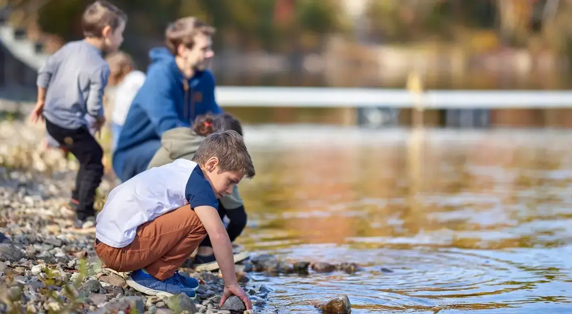 Children playing near a lake.