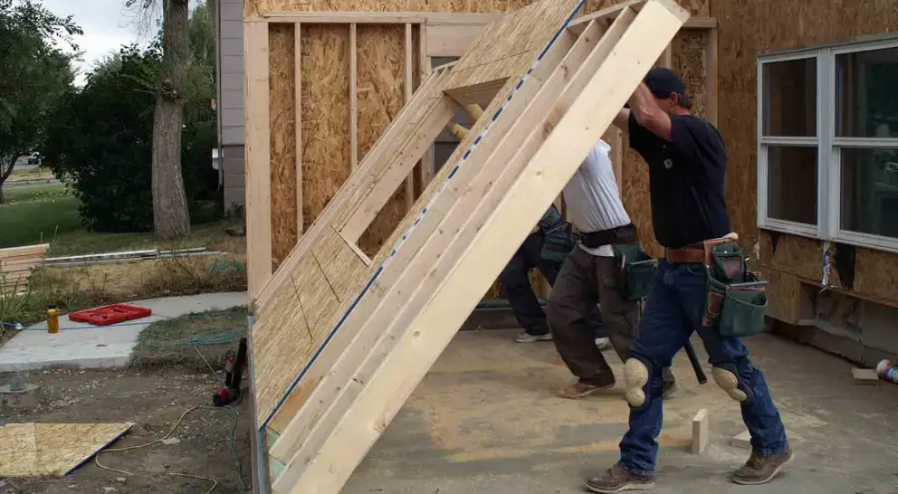 Building contractors raising a wall for a room addition.