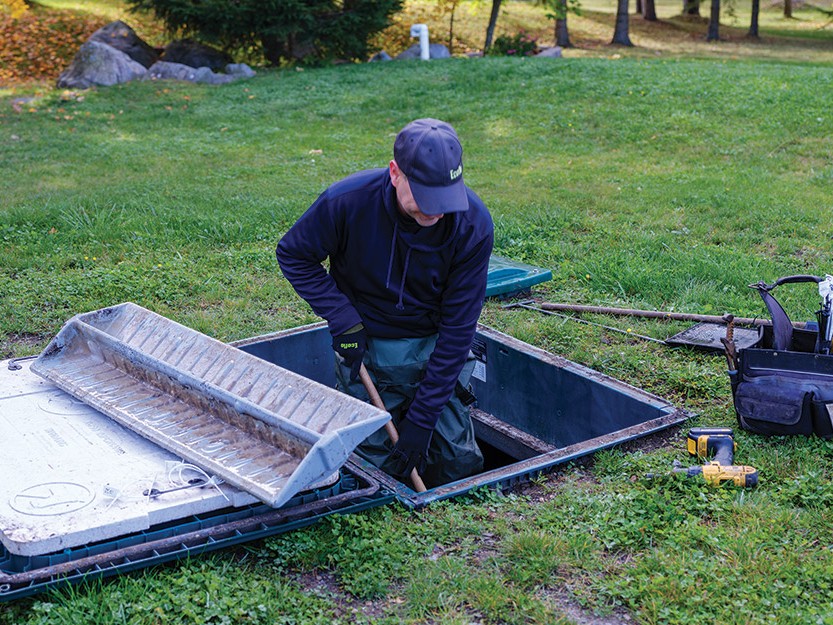 Technicien de service de Premier Tech qui entretient un biofiltre Ecoflo.