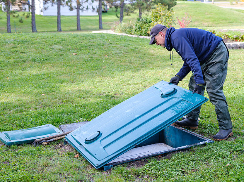 Technicien Premier Tech Eau et Environnement vérifiant le bon fonctionnement du biofiltre compact Ecoflo.