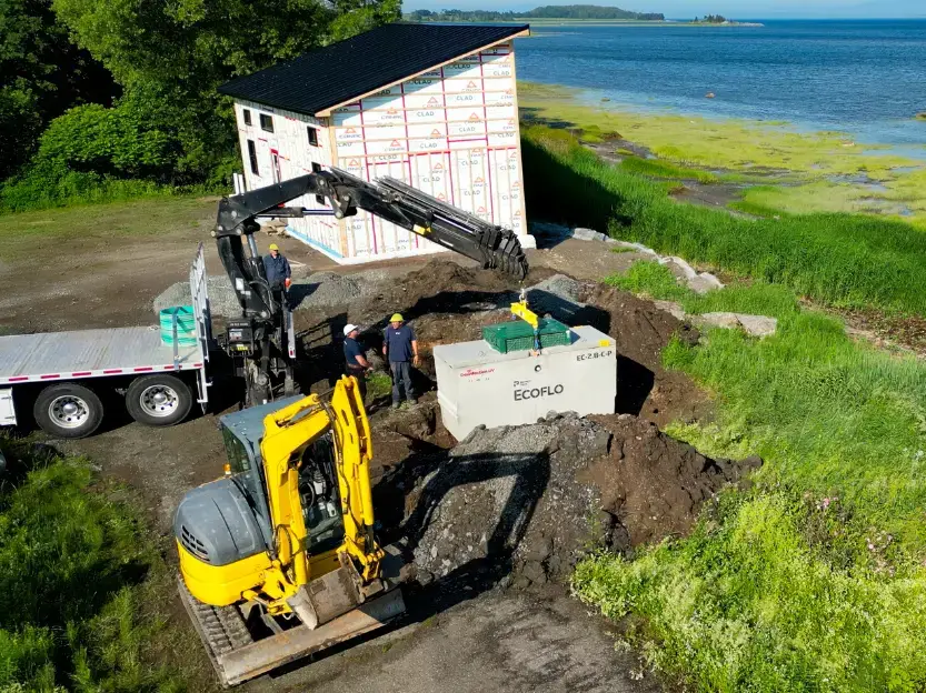Installation d'un biofiltre compact Ecoflo sur un petit terrain en bordure de rivière.