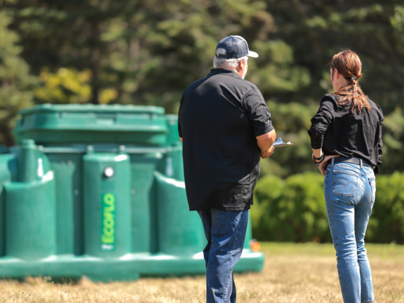 Client discutant avec un expert Premier Tech devant une biofiltre Ecoflo.