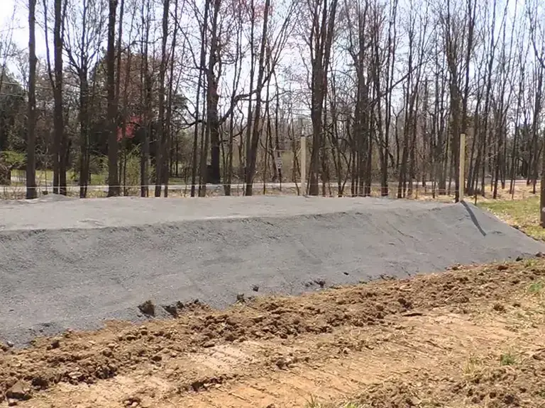 Large sand filter septic system being installed at the site of a new home construction.
