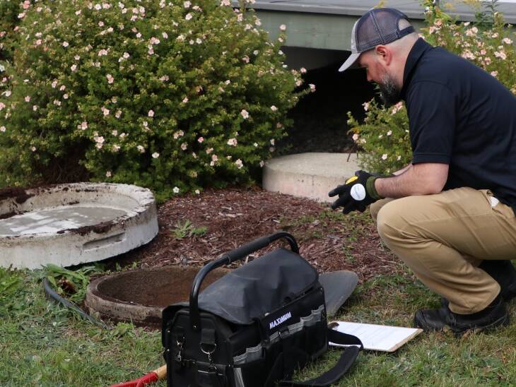 Premier Tech technician inspecting an ageing septic tank.
