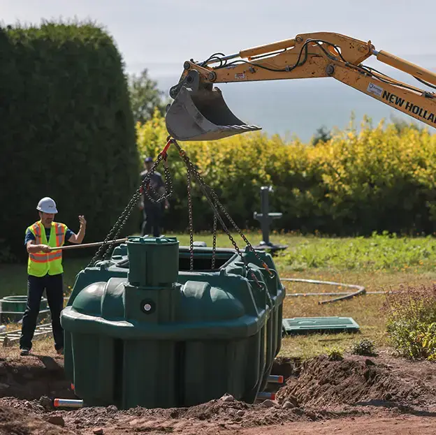 Excavator and septic installers lowering the Ecoflo biofilter septic system into a residential property.