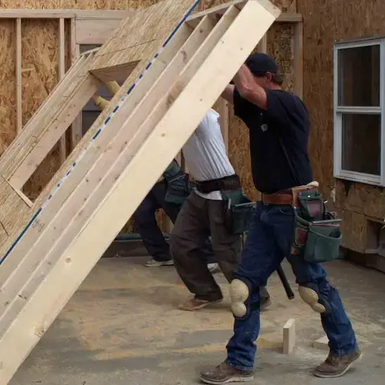 Building contractors raising a wall for a room addition.