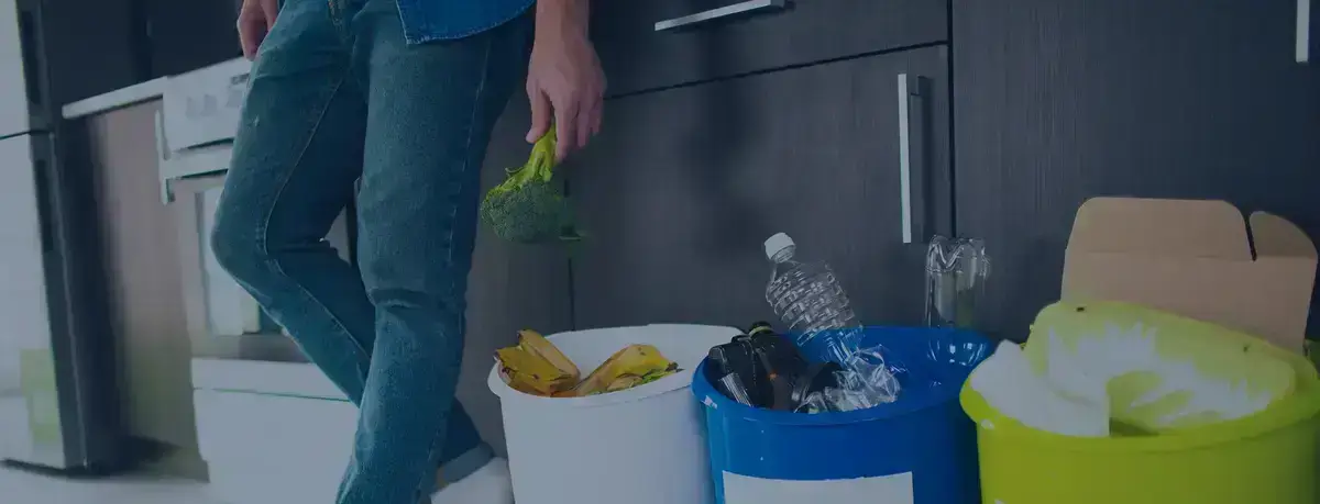 Person putting recyclables into kitchen bins.