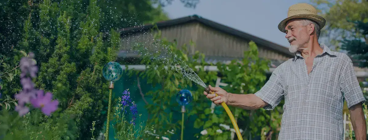  Man watering his garden with water collected from the Rewatec rainwater harvesting system.