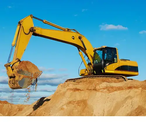 Large yellow excavator scooping sand out of a pit.