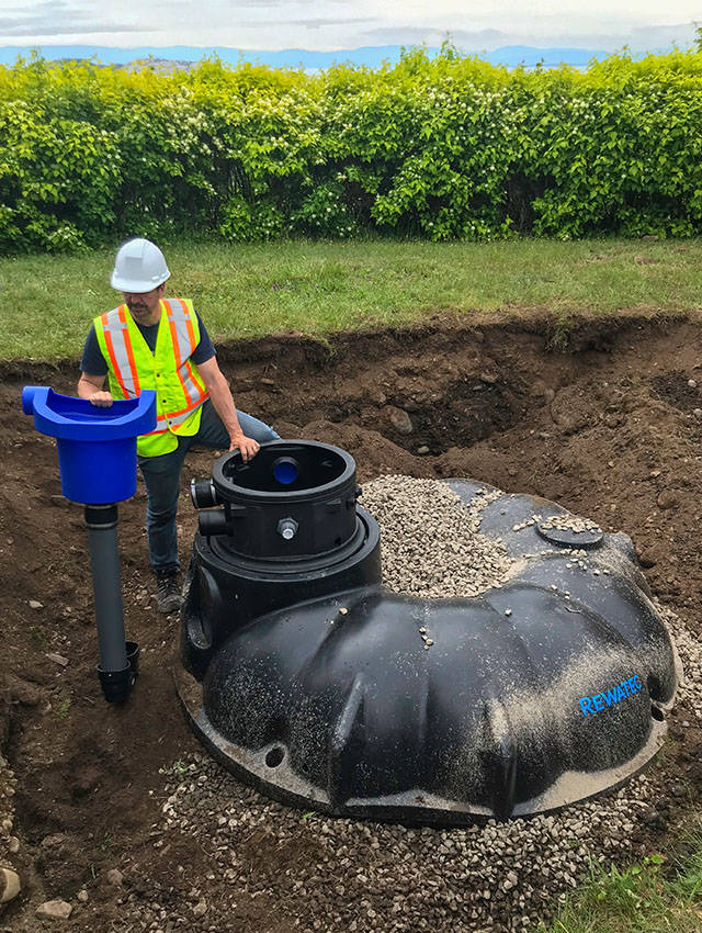 Installation d'un réservoir de récupération d'eau de pluie.